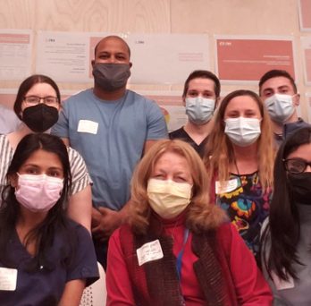 Faculty mentors and health sciences students posing together, wearing masks. 