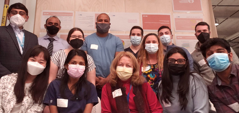 Faculty mentors and health sciences students posing together, wearing masks.