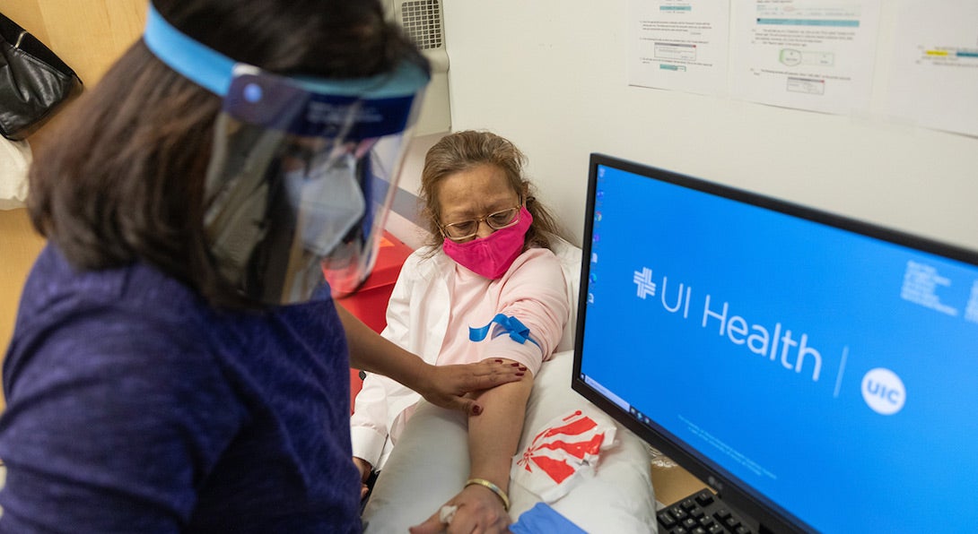 woman giving blood sample to UI health nurse as part of the study