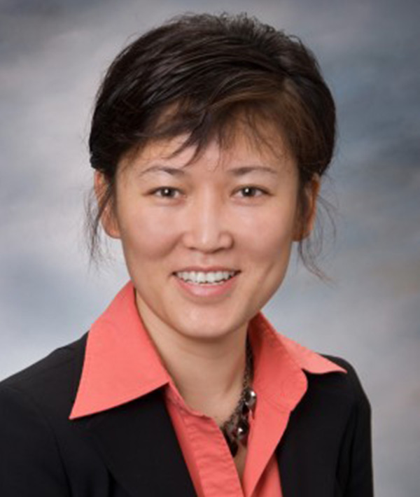 photo of Dr. Ma in a salmon colored blouse and black suit coat