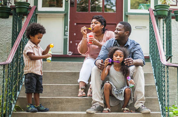 photo of African American mother and father with young children on the stoop of their home