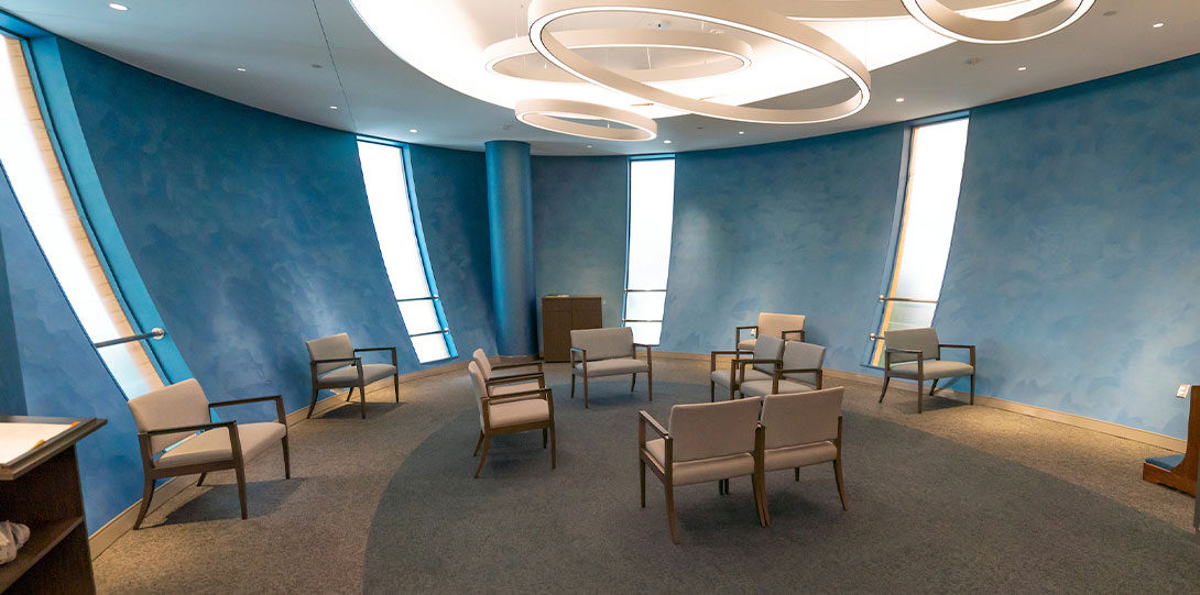 an oval-shaped room with seating and soothing blue walls