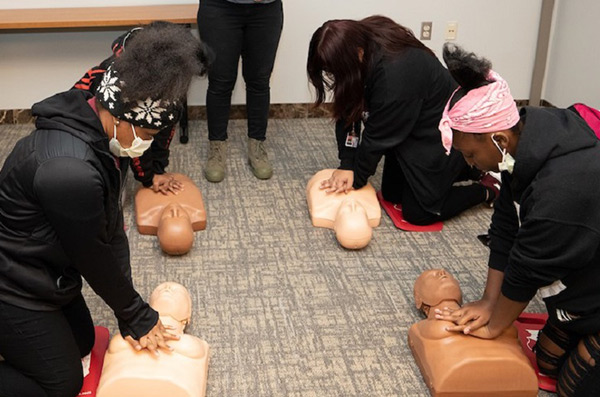 community members training on CPR mannequins
