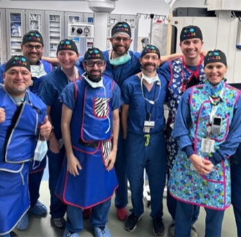 UI Health surgeons in scrubs posing together in an operating room 