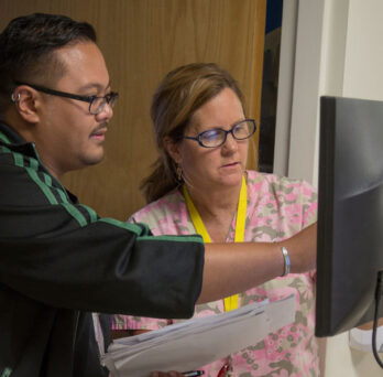 two UI Health professionals looking at data on a computer screen 