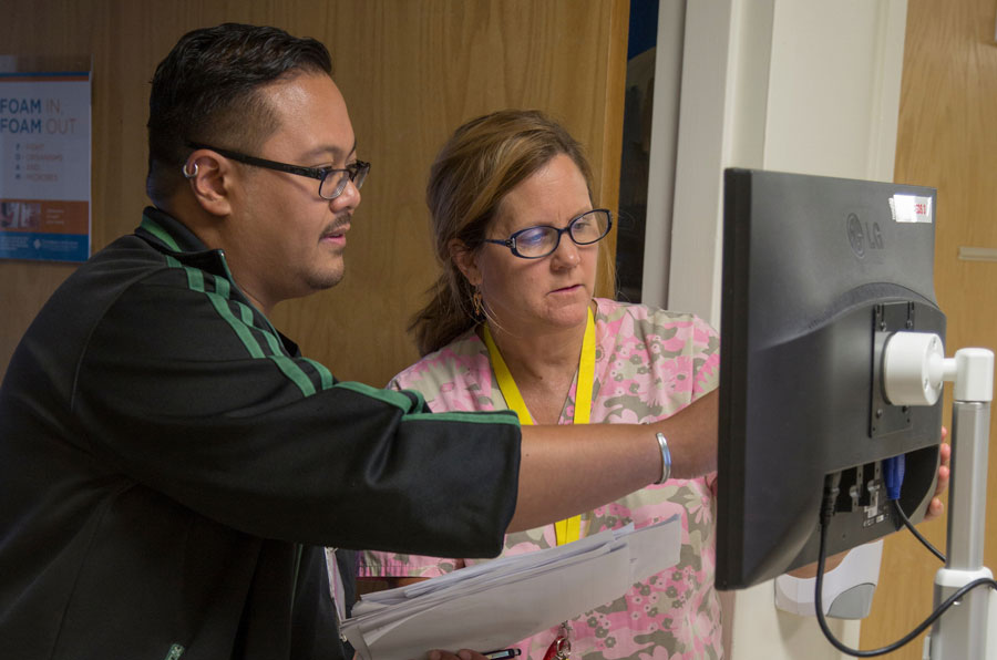 two UI Health professionals looking at data on a computer screen
