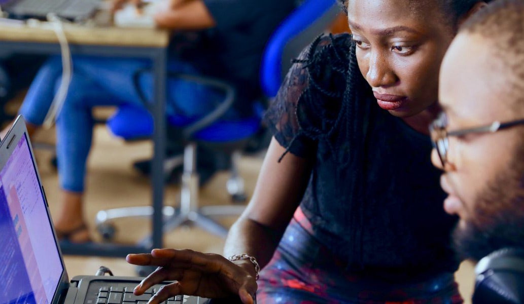 two African American researchers looking at data on a computer screen