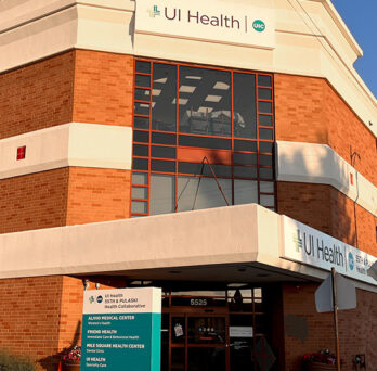 looking up at the UI health sign on the front of the building on a bright sunny day 