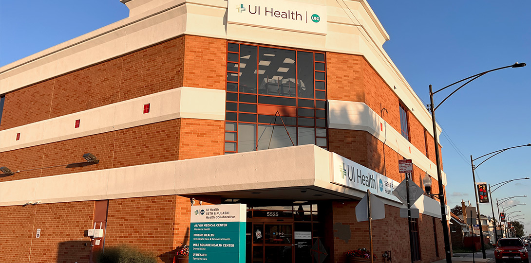 looking up at the UI health sign on the front of the building on a bright sunny day