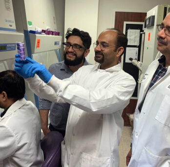 UIC researchers in white lab coats working in their laboratory 