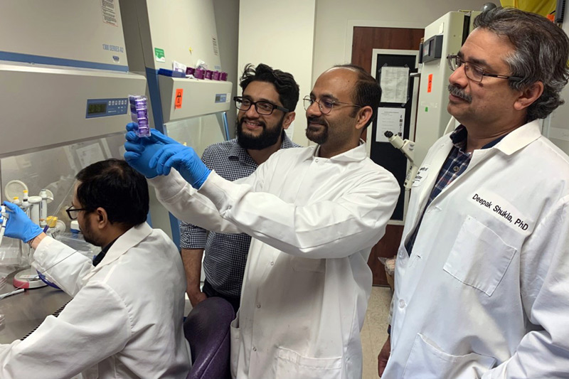 UIC researchers in white lab coats working in their laboratory
