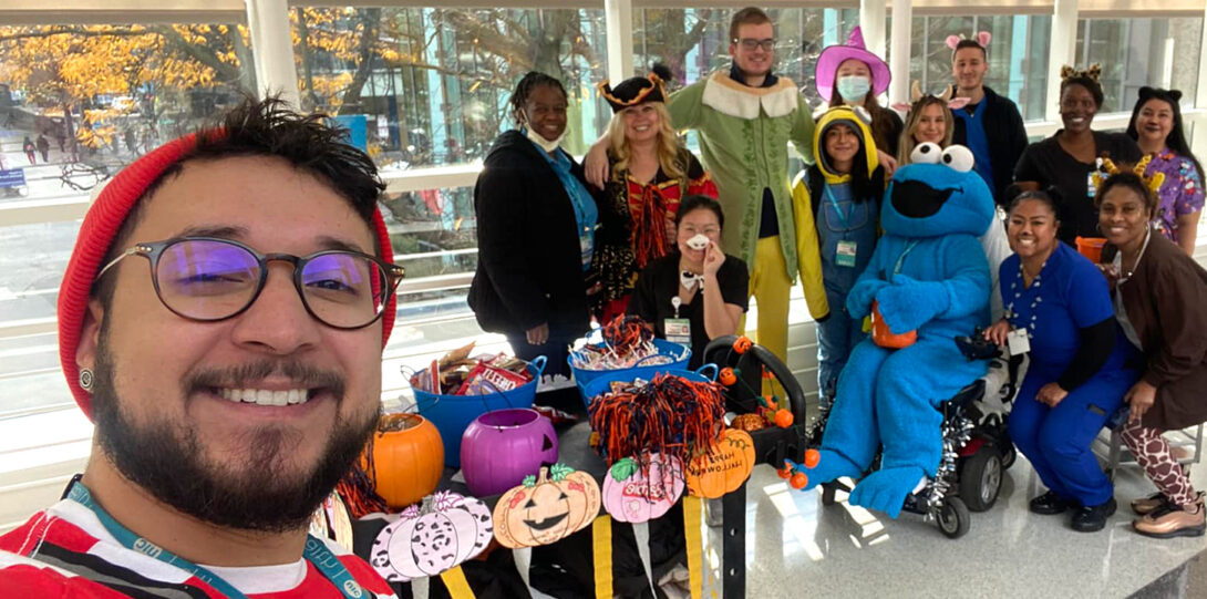 people in various costumes with a cart loaded with candy and treats