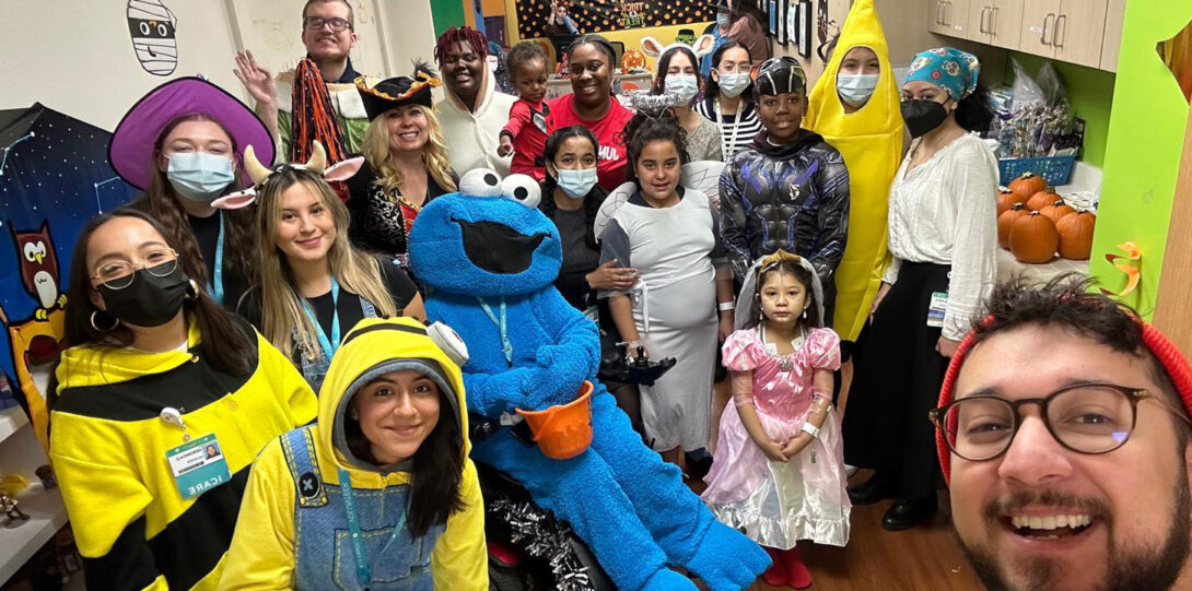 Staff and children, all in costumes and posing and smiling together