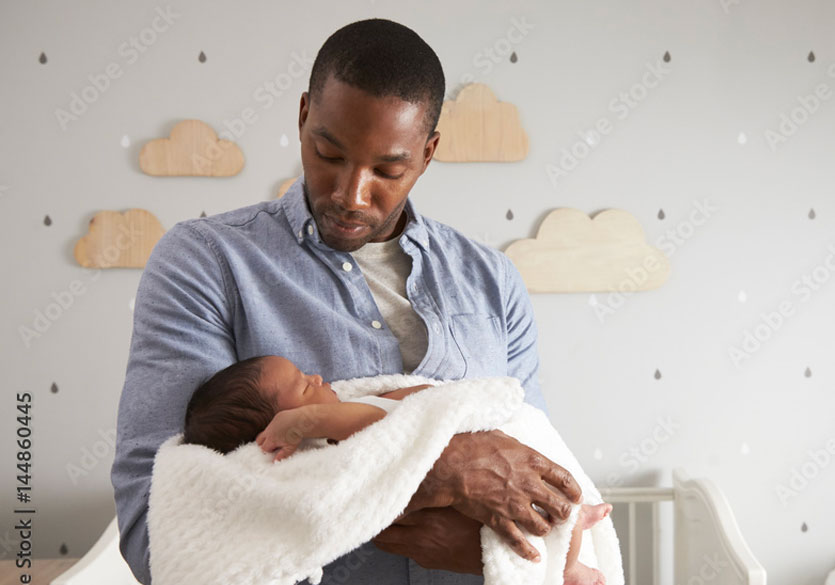 African American father cradling his young infant