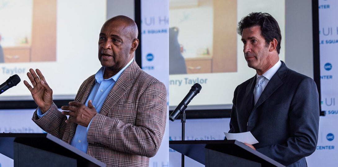 : at left, an older African American man wearing a brown plaid jacket and blue shirt standing at a podium and speaking into a microphone, and at right, a man with dark hair and wearing a dark gray suite, white shirt and gray necktie, standing at a podium and speaking into a microphone