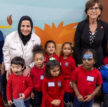 College of Dentistry faculty posing with a group of small children from the community
                  