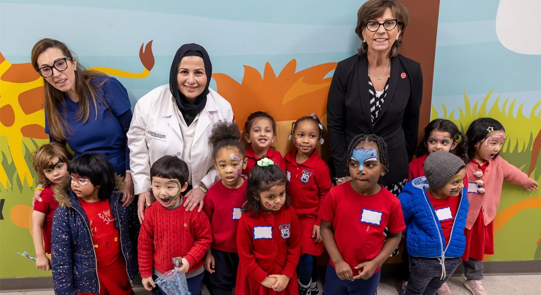 College of Dentistry faculty posing with a group of small children from the community